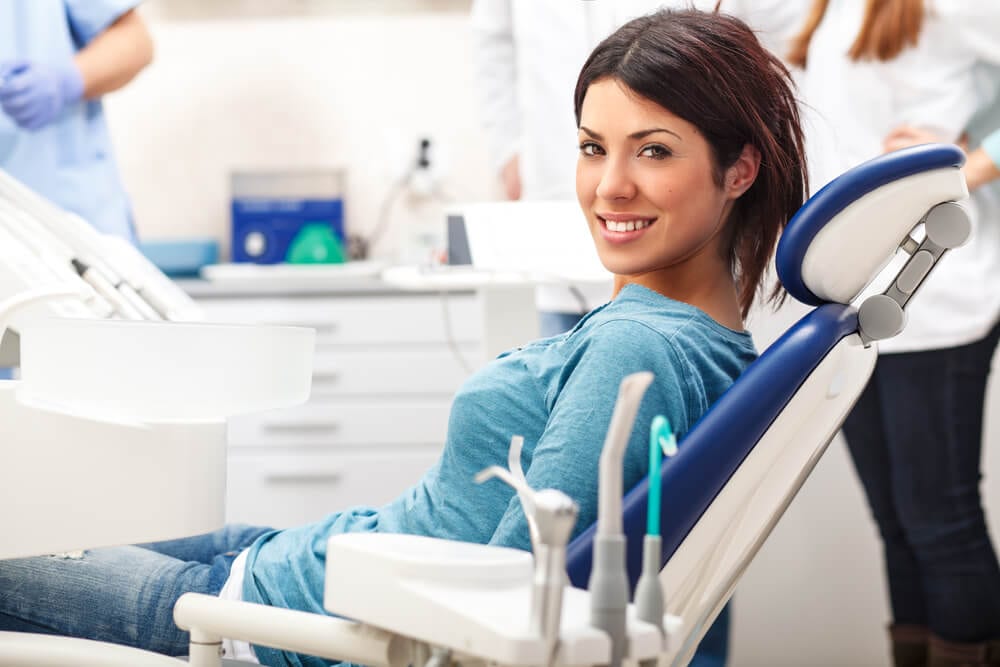 waiting female in dental chair with blue shirt
