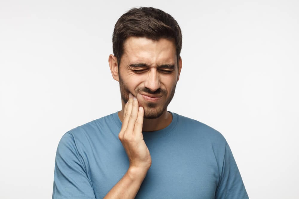 male holding jaw from TMJ pain
