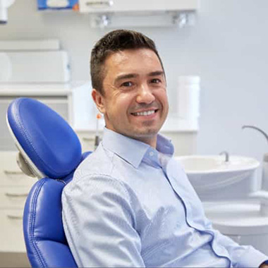 smiling hispanic male in dental chair